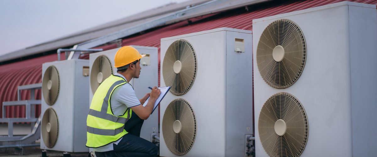 Engineers is checking the air conditioning cooling system of a major building or industrial facility. Background is solar cell on the roof.